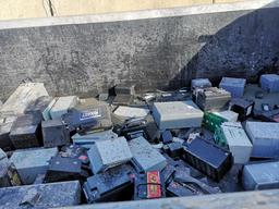 Broken lead-acid batteries in a plastic lined steel pit